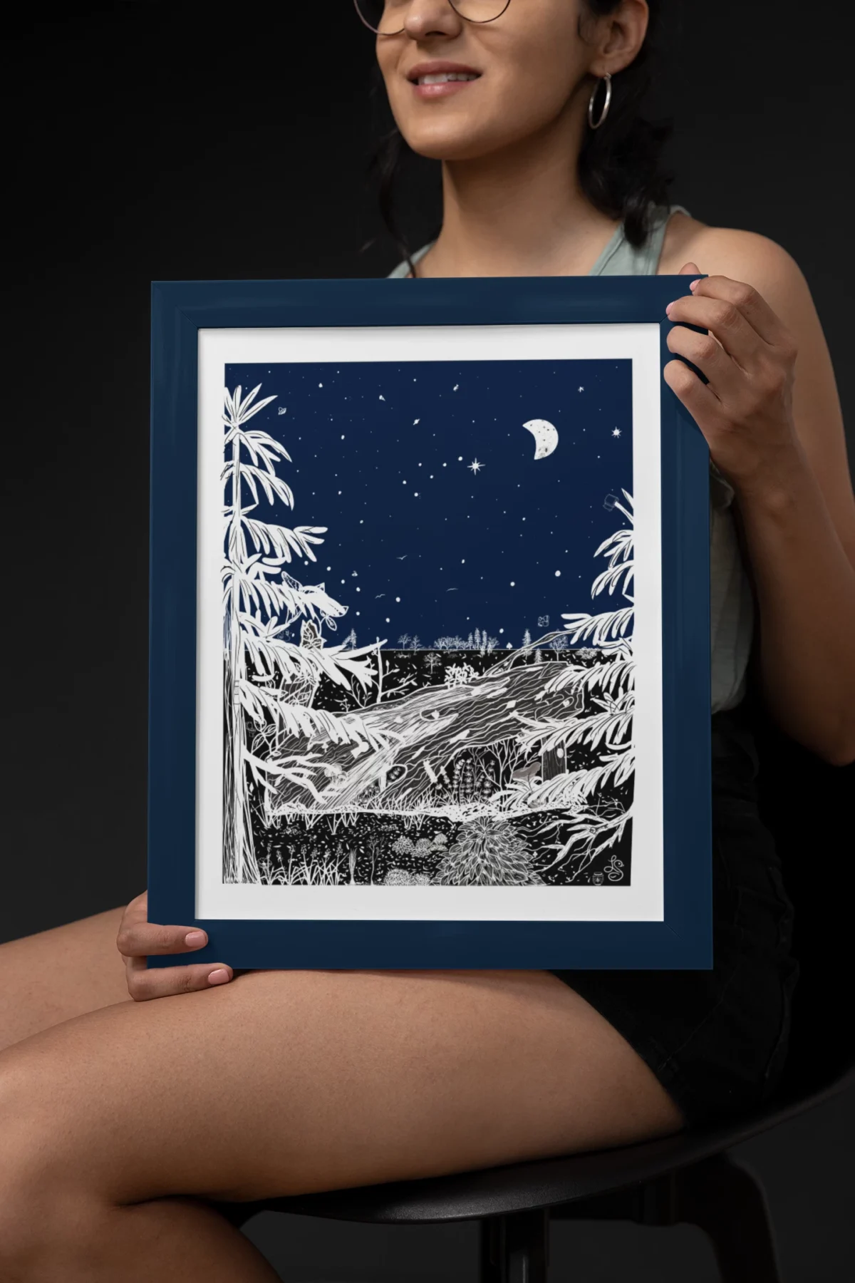 Autumn Before Dawn part of the Vintage Series by Line & Blossom Design in a Navy blue frame held by a seated smiling woman