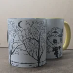 black and white art. Winter Trees mug with the Poppy Mug in the background